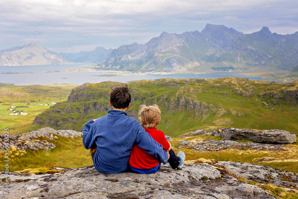 Fototapeta premium Happy children with parents and dog, european family, hiking the Kvalvika trail on hill at Kvalvika beach, Norway
