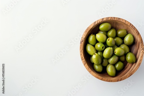 A beautiful wooden bowl filled with fresh green olives sits on a clean white background. Healthy and delicious, perfect for snacks and recipes. Generative AI