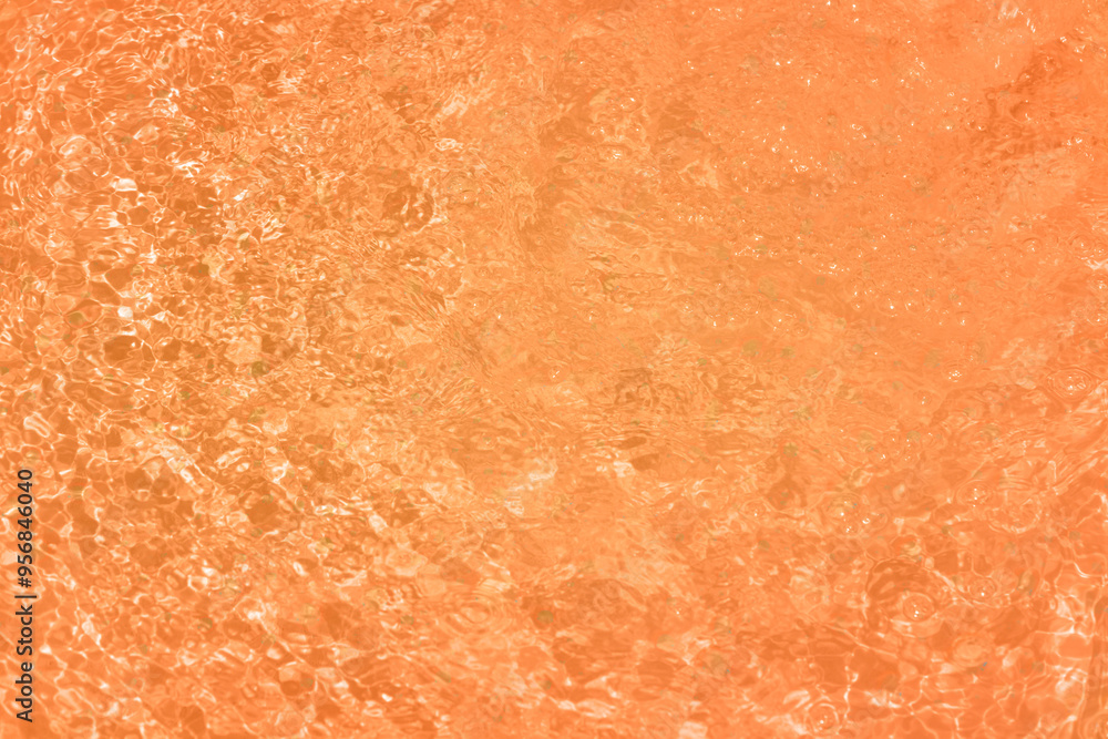 Orange water with ripples on the surface. Defocus blurred transparent blue colored clear calm water surface texture with splashes and bubbles. Water waves with shining pattern texture background. Orange water with ripples on the surface. Defocus blurred transparent blue colored clear calm water surface texture with splashes and bubbles. Water waves with shining pattern texture background.