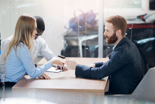 Wallpaper Mural Closeup salesman giving keys to happy new car owners clients at dealership office Torontodigital.ca