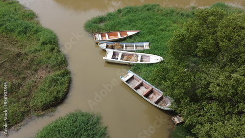 Obraz na płótnie A view of several fishing boats on a brown water river w salonie