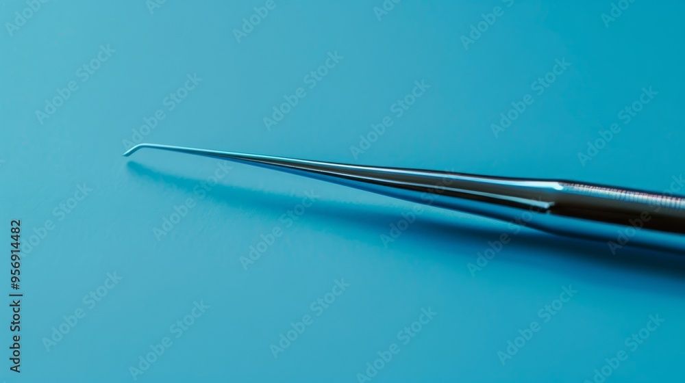 Close-up of a shiny, intricate dental tool on a soft blue background, emphasizing its precise and delicate design. Close-up of a shiny, intricate dental tool on a soft blue background, emphasizing its precise and delicate design.