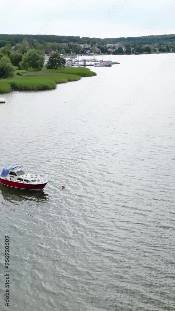 boat anchored in lake coast blue waves water outwards flying away aerial drone boat anchored in lake coast blue waves water outwards flying away aerial drone
