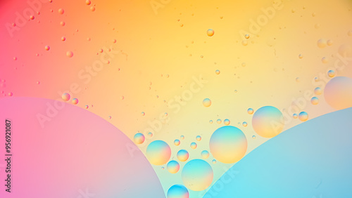 Top view of movement of oil bubbles in liquid. Fantastic colorful bubble structure. Colorful artistic image of oil droplets floating on water. Macro shot of water oil emulsion over colored background.