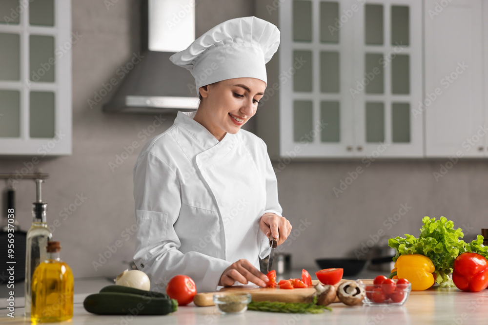 Professional chef cutting tomato at table in kitchen Professional chef cutting tomato at table in kitchen