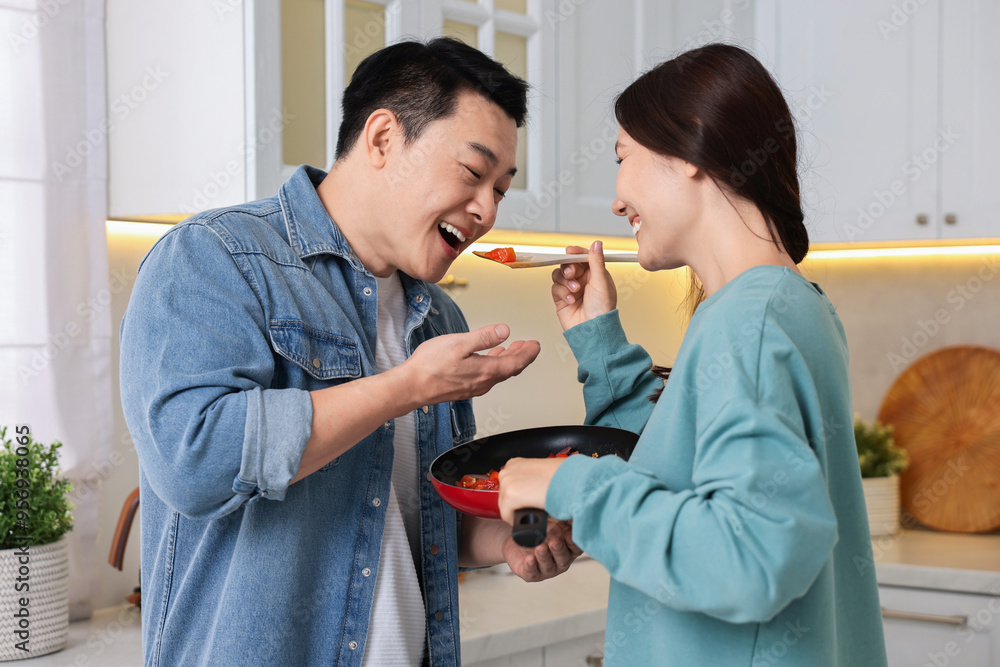 Fototapeta premium Happy lovely couple cooking together in kitchen
