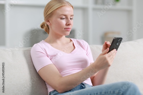 Photography Beautiful woman using smartphone on sofa indoors