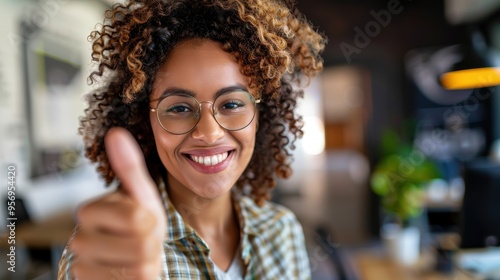 Wallpaper Mural Smiling woman wearing glasses shows a thumbs up in an eyewear shop, representing vision care and health with a gesture of success and approval Torontodigital.ca
