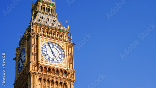 Photography Close-up of Big Ben tower with a clear blue sky background, iconic London landmark