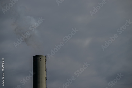 Industrie-Schornstein vor bewölktem Himmel photo