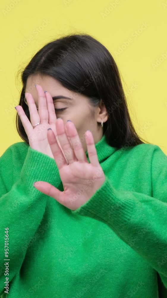 Scared young adult Caucasian woman in panic covering face, standing on yellow background. Concept of a negative emotions. Vertical video. Scared young adult Caucasian woman in panic covering face, standing on yellow background. Concept of a negative emotions. Vertical video.