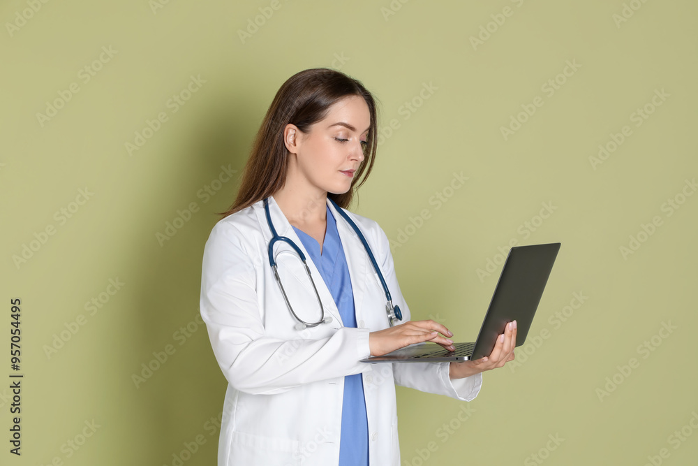 Professional nurse working with laptop on pale green background Professional nurse working with laptop on pale green background