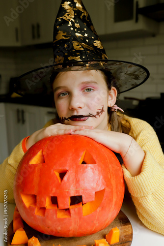 a girl in a black hat and with a pumpkin photo