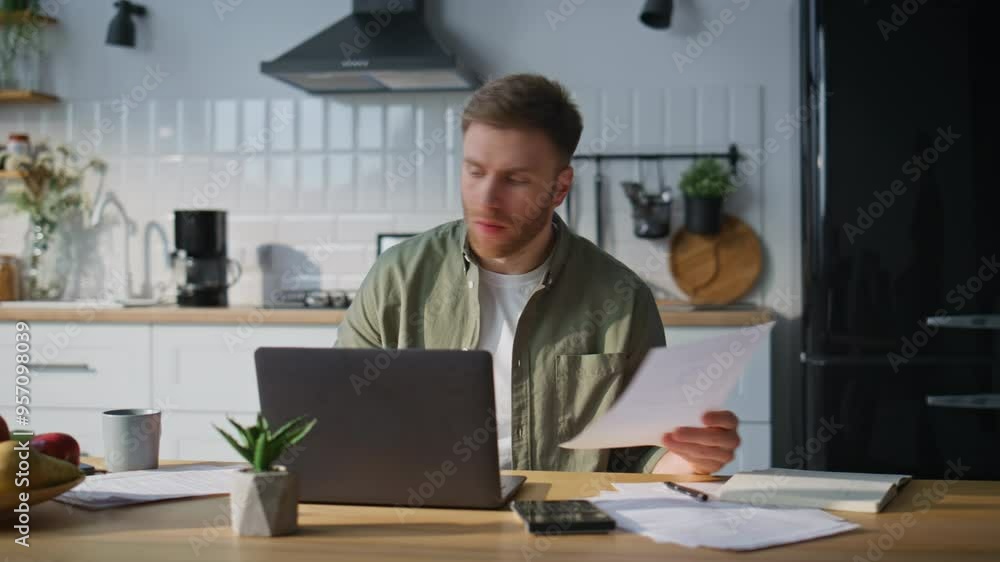 Focused professional reading paper at home office. Bearded freelancer analyzing Focused professional reading paper at home office. Bearded freelancer analyzing