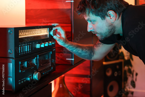 Man at night selecting song to play on the radio with cozy soft light
