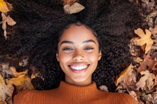 Multicultural diverse portrait of a smiley child with afro hair in autumn season leaves photo