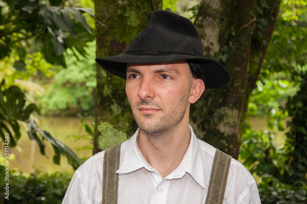 Portrait of a young man wearing a hat and suspenders. in Oktoberfest Portrait of a young man wearing a hat and suspenders. in Oktoberfest