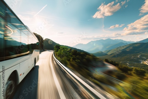 A blurred motion shot of a bus speeding along a scenic mountain road under a bright blue sky. photo