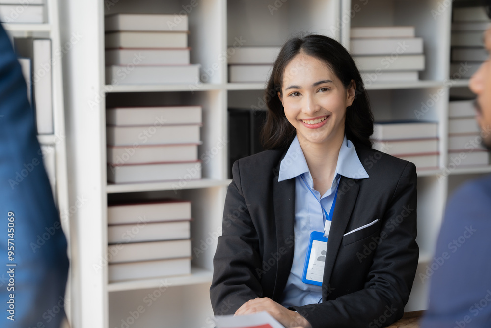 Confident Candidate's Warm Smile: A young professional radiates confidence during a job interview, engaging with potential employers in a modern office setting. Confident Candidate's Warm Smile: A young professional radiates confidence during a job interview, engaging with potential employers in a modern office setting.