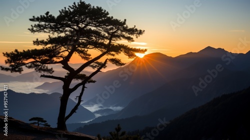 Stunning silhouette of a solitary tree at sunset on the edge of a breathtaking mountain landscape