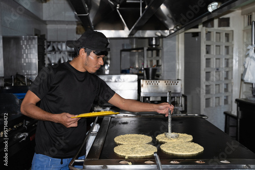 A chef putting cachapa dough on the griddle photo