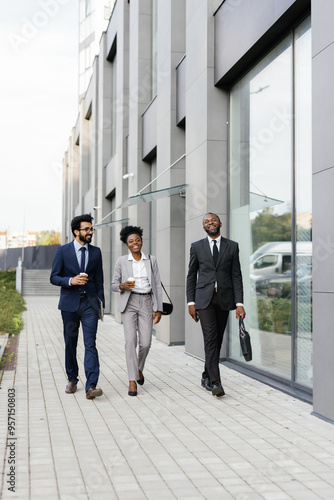 Businessman walking with business associates past corporate building