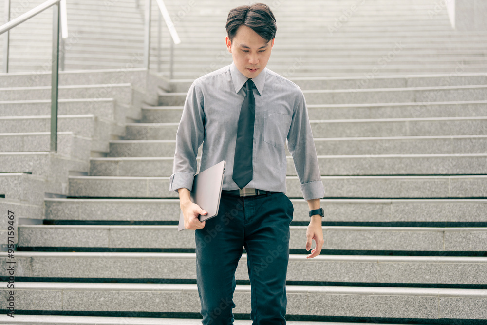 Asian businessman walking to work diligently and briskly in the morning in a big city. A man in a business suit, dressed in a smart suit, runs to work during rush hour in corridors and stairs. Asian businessman walking to work diligently and briskly in the morning in a big city. A man in a business suit, dressed in a smart suit, runs to work during rush hour in corridors and stairs.
