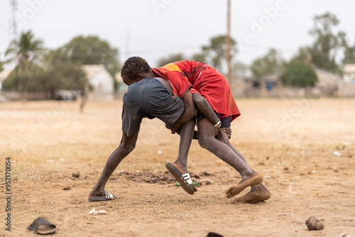 Two young senegalese boys wrestling in a rural village