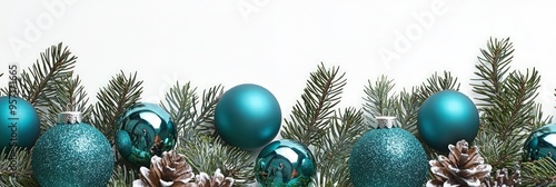 Wide perspective of teal baubles and green pine on a pristine white background.