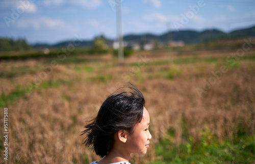 Close-up of a little Chinese girl's head outdoors in a field photo