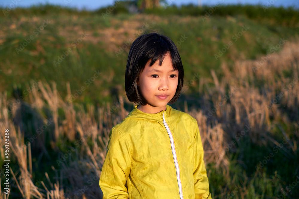 A little Chinese girl playing in the fields under the sun A little Chinese girl playing in the fields under the sun