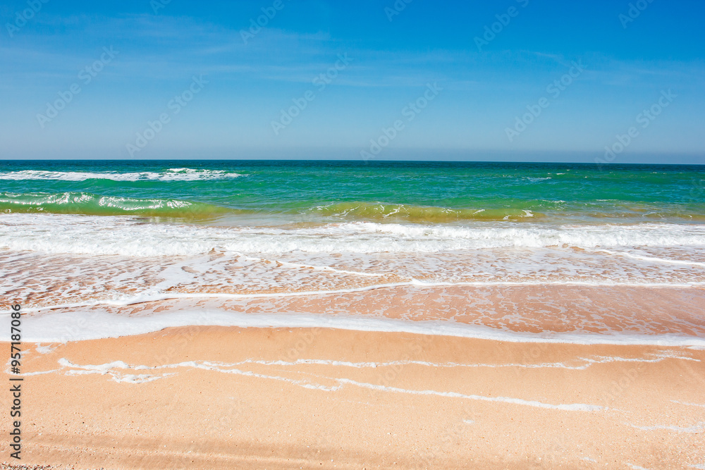 Fototapeta premium view of ocean waves rolling in sand beach sunny day