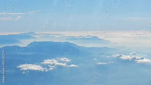 Aerial view of Apennine Mountains in couds and mist, sun rays and horizon with blue sunny sky above. Topics: Apennines, air travel, space over land, Italy, Europe, weather, meteorology, vacation