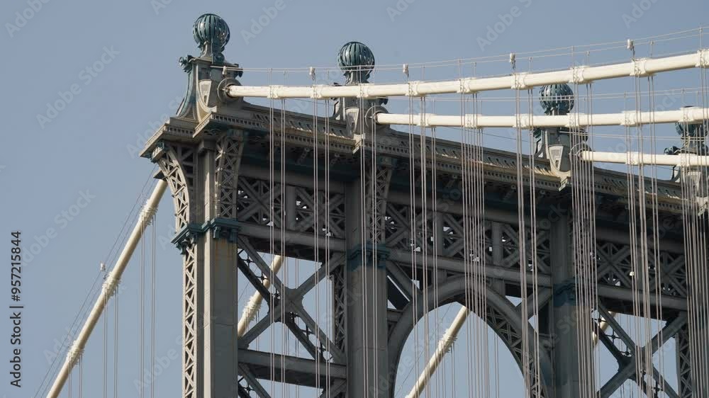 A close-up of the ornate top of the Manhattan Bridge, focusing on the intricate design and cables that make up this iconic New York structure. A close-up of the ornate top of the Manhattan Bridge, focusing on the intricate design and cables that make up this iconic New York structure.