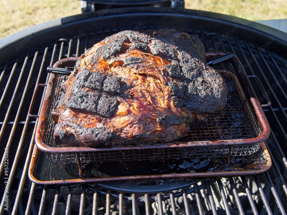 Pork shoulder smoked on a charcoal grill for pulled pork