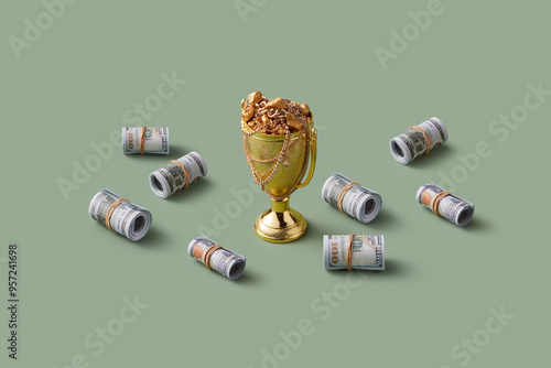 Bundles of dollar bills laying around golden cup with jewels