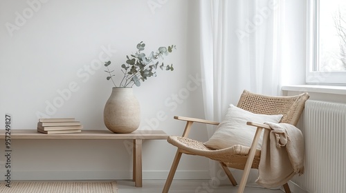 A cozy minimalist living space featuring a wooden chair, decorative vase, and warm natural light.