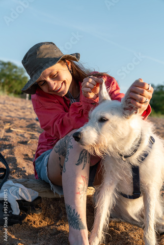 Woman Playing with Her Dog's Ears on the Beach photo