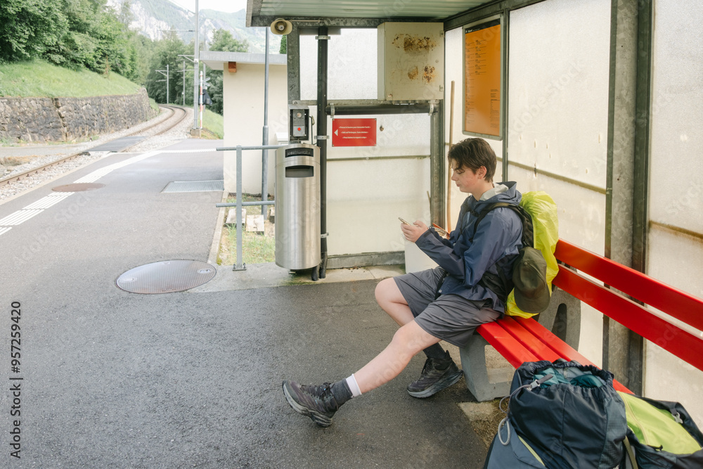 teen boy waiting for train during a backpacking trip teen boy waiting for train during a backpacking trip