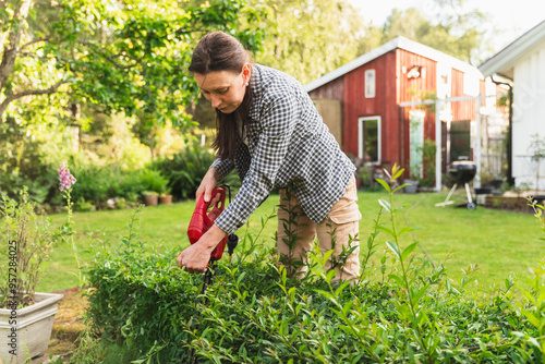  Mature Woman Using Hedge Trimmer