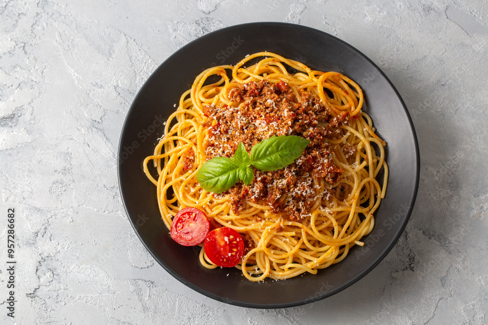 Pasta spaghetti bolognese with minced beef sauce, tomatoes, parmesan cheese and fresh basil in a plate