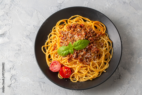 Pasta spaghetti bolognese with minced beef sauce, tomatoes, parmesan cheese and fresh basil in a plate