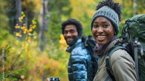Smiling Couple Enjoying a Hike in a Forest During Autumn with Backpacks and Warm Clothing