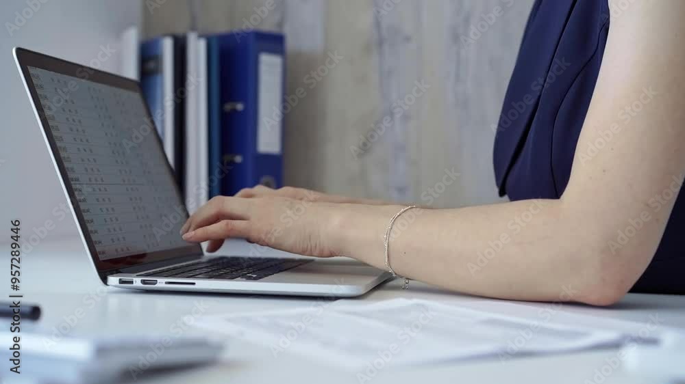 Woman with dark blue blues is working from home office typing on laptop computer keyboard. Business concept Woman with dark blue blues is working from home office typing on laptop computer keyboard. Business concept