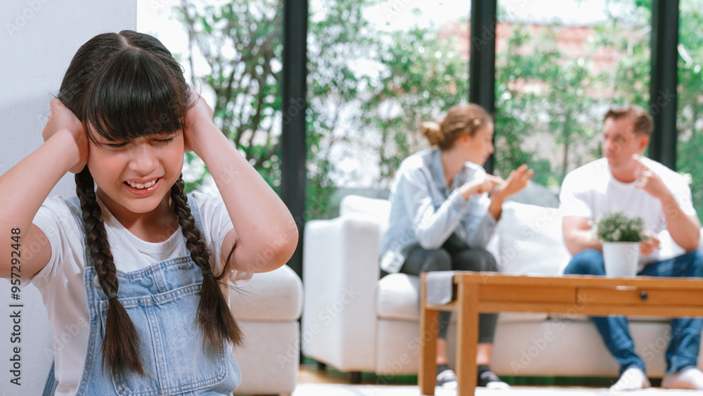 Stressed and unhappy young girl huddle in corner, cover her ears blocking sound of her parent arguing in background. Domestic violence at home and traumatic childhood develop to depression. Synchronos Stressed and unhappy young girl huddle in corner, cover her ears blocking sound of her parent arguing in background. Domestic violence at home and traumatic childhood develop to depression. Synchronos