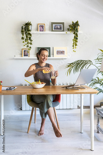 Healthy woman pouring kombucha in home office, aspiring lifestyle photo