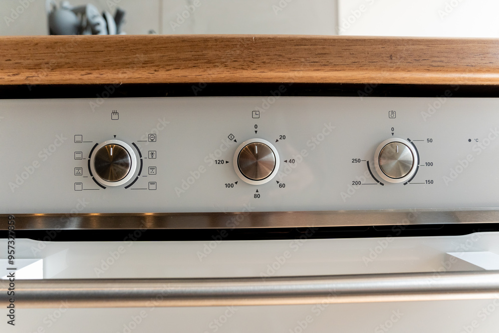 Fototapeta premium A closeup of a stainless steel oven with three knobs