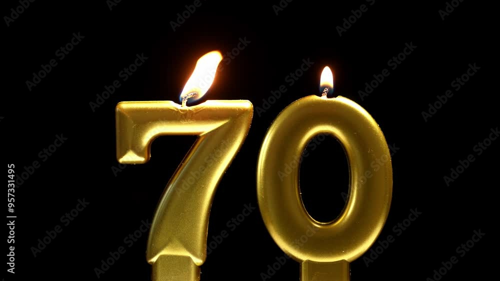 Golden number 70 birthday candle burning against a black background, creating a sleek and elegant celebration scene. Golden number 70 birthday candle burning against a black background, creating a sleek and elegant celebration scene.