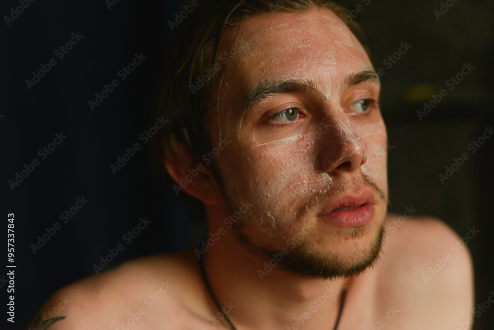 Pensive man with a face cream Pensive man with a face cream