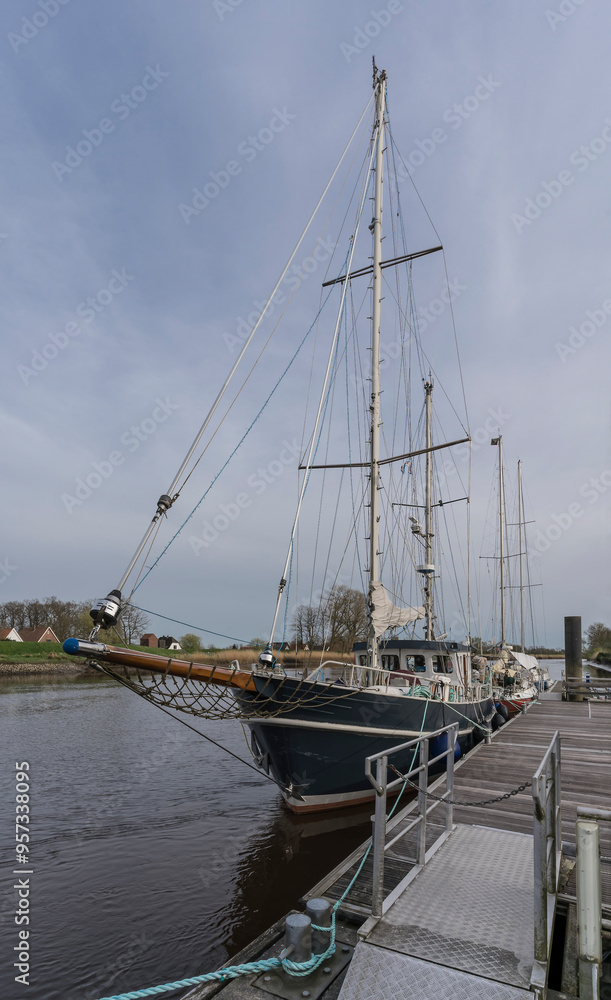 picture of a sailing ship on a pier in a little river picture of a sailing ship on a pier in a little river